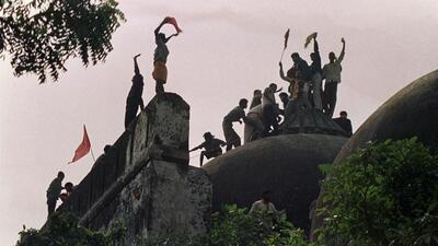 (FILES) This file photo taken on December 6, 1992 shows Hindu kar sewaks shouting and waving banners as they stand on the top of a stone wall and celebrate the destruction of the 16th Century Babri Mosque in Ayodhya. AFP PHOTO / FILES / DOUGLAS E. CURRAN / AFP PHOTO / FILES AFP / DOUGLAS E. CURRAN (AFP)