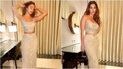 The silver bustier and floor-length skirt comes decked in tassels, sequins, and shimmering bead embellishments. While the blouse has a strapless design, a plunging neckline, a fitted silhouette, and a cropped hem, the bodycon skirt has a floor-sweeping hem, a gold buckle embellishment on the waist, and a mermaid fit. Open locks and striking glam picks rounded it off. (Instagram) The silver bustier and floor-length skirt comes decked in tassels, sequins, and shimmering bead embellishments. While the blouse has a strapless design, a plunging neckline, a fitted silhouette, and a cropped hem, the bodycon skirt has a floor-sweeping hem, a gold buckle embellishment on the waist, and a mermaid fit. Open locks and striking glam picks rounded it off. (Instagram)
