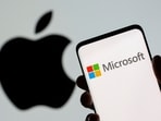 Microsoft logo is seen on the smartphone in front of displayed Apple logo in this illustration taken.