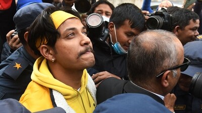 (FILES) Nepali former national cricket captain Sandeep Lamichhane (L) is escorted by police outside the districtl court (AFP)