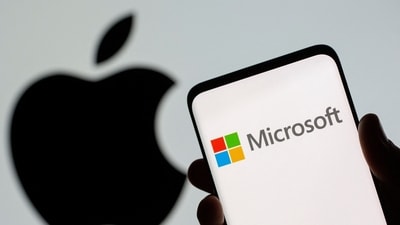 Microsoft logo is seen on the smartphone in front of displayed Apple logo in this illustration taken. (REUTERS)