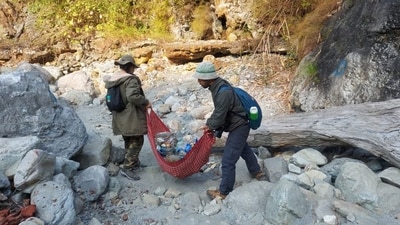 Dukchen Bhutia (left) collecting trash thrown away by tourists with her team. (X/@ParveenKaswan) Dukchen Bhutia (left) collecting trash thrown away by tourists with her team. (X/@ParveenKaswan)