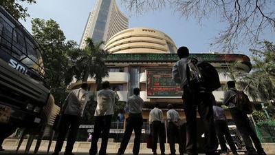 People look at a screen displaying the Sensex results on the facade of the Bombay Stock Exchange (BSE) building in Mumbai. (REUTERS)