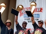 The Chicago Bulls players, from left, Dennis Rodman, left, Michael Jordan and Scottie Pippen, hoist three of the team's NBA Championship trophies during a celebration in Chicago's Grant Park on June 16, 1997.