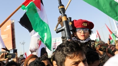 A child holds up a mock RPG, as supporters of the Houthi movement rally to denounce air strikes launched by the US and Britain on Houthi targets in Sanaa, Yemen. (REUTERS)