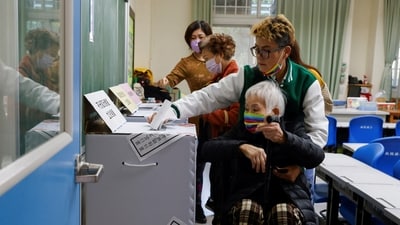 A woman is assisted in casting her vote at a polling station during the presidential and parliamentary elections in New Taipei City, Taiwan January 13, 2024. (REUTERS)