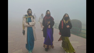 Tourists visit the Taj Mahal during a cold and foggy winter morning, in Agra, Saturday. (PTI)