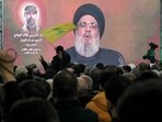 A man waves a Hezbollah movement flag as its leader Hassan Nasrallah delivers a televised speech in Kherbet Selm in southern Lebanon on January 14, 2024. A man waves a Hezbollah movement flag as its leader Hassan Nasrallah delivers a televised speech in Kherbet Selm in southern Lebanon on January 14, 2024.
