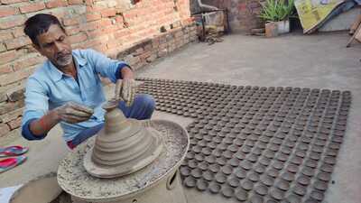A potter busy making earthen lamps in Prayagraj. (HT Photo)