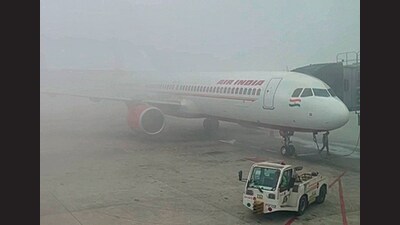 Fog drapes an aircraft at the Delhi airport on Sunday morning. (ANI)