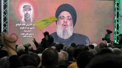 A man waves a Hezbollah movement flag as its leader Hassan Nasrallah delivers a televised speech in Kherbet Selm in southern Lebanon on January 14, 2024. (AFP) A man waves a Hezbollah movement flag as its leader Hassan Nasrallah delivers a televised speech in Kherbet Selm in southern Lebanon on January 14, 2024. (AFP)