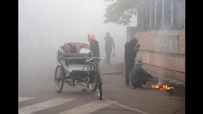 People sit around a bonfire amid dense fog on a cold winter morning, in Lucknow, Sunday. (PTI) People sit around a bonfire amid dense fog on a cold winter morning, in Lucknow, Sunday. (PTI)