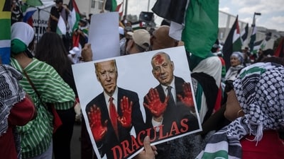 A Pro-Palestinian protester holds a placard depicting US President Joe Biden (L on poster) and Israel's Prime Minister Benjamin Netanyahu (R on poster). (Photo by DAVIDE LONGARI / AFP) (AFP) A Pro-Palestinian protester holds a placard depicting US President Joe Biden (L on poster) and Israel's Prime Minister Benjamin Netanyahu (R on poster). (Photo by DAVIDE LONGARI / AFP) (AFP)