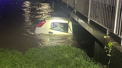 The image shows a car that was trapped under a bridge. A man rescued a woman and her kid from the car. (X/@dronesWMP) The image shows a car that was trapped under a bridge. A man rescued a woman and her kid from the car. (X/@dronesWMP)
