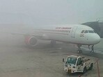 Fog drapes an aircraft at the Delhi airport on Sunday morning. (ANI)