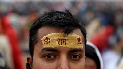 A Hindu devotee, with the word "Ram" written on his forehead, arrives to take a holy dip on the banks of the Sangam to mark Makar Sankranti. (REUTERS)