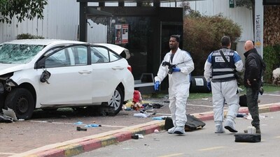 Israeli police forensics personnel inspect a damaged car following a suspected ramming attack in the central town of Raanana. (AFP) Israeli police forensics personnel inspect a damaged car following a suspected ramming attack in the central town of Raanana. (AFP)