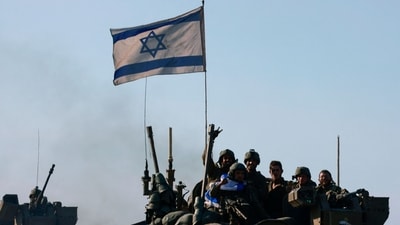 A picture taken from the Israeli border with Gaza shows Israeli soldiers in an armoured vehicle convoy returning from the Palestinian territory on January 15, 2024, amid ongoing battles between Israel and the Palestinian Hamas militant group. (AFP)