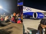 In a viral video, passengers of a Delhi-bound IndiGo flight diverted to Mumbai due to operational issues are seen eating and sitting on the airport tarmac at Mumbai Airport, in Mumbai on Monday. In a viral video, passengers of a Delhi-bound IndiGo flight diverted to Mumbai due to operational issues are seen eating and sitting on the airport tarmac at Mumbai Airport, in Mumbai on Monday.