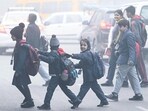 School-going children find their way through heavy fog on a winter morning. School-going children find their way through heavy fog on a winter morning.