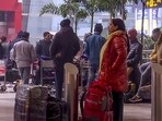 Passengers await at the Indira Gandhi International Airport on a cold winter morning in New Delhi on Tuesday.