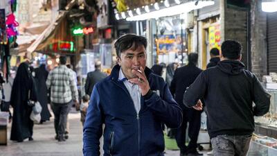 A man smokes a cigarette as he walks at the old bazaar in the city of Shahr-e Ray, south of Tehran, Iran on January 8. (AFP) A man smokes a cigarette as he walks at the old bazaar in the city of Shahr-e Ray, south of Tehran, Iran on January 8. (AFP)
