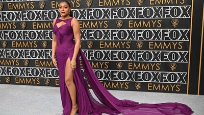 Taraji P. Henson exuded elegance at the 75th Emmy Awards in a purple floor-length gown featuring neck cut-outs, a risqué thigh-high slit, a train on the back, and a figure-hugging silhouette. It is from Atelier Versace. She styled it with silver high heels, stacked diamond bracelets, rings, earrings, striking makeup, and a sleek ponytail. (AFP) Taraji P. Henson exuded elegance at the 75th Emmy Awards in a purple floor-length gown featuring neck cut-outs, a risqué thigh-high slit, a train on the back, and a figure-hugging silhouette. It is from Atelier Versace. She styled it with silver high heels, stacked diamond bracelets, rings, earrings, striking makeup, and a sleek ponytail. (AFP)