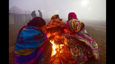 People sit around a bonfire to warm themselves during a cold and foggy winter morning, in Prayagraj, Tuesday. (PTI) People sit around a bonfire to warm themselves during a cold and foggy winter morning, in Prayagraj, Tuesday. (PTI)