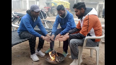 People sit by a bonfire in Malout onTuesday. Intense cold wave conditions prevailed in Punjab and Haryana on Tuesday, with Ballowal Saunkhri in Shaheed Bhagat Singh Nagar district recording a low of minus 0.4 degree Celsius. (Sanjeev Kumar /HT)