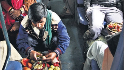 STORY ON RAILWAY , DELHI TO MUMBAI -- vendors selling fruits in Sleeper class coach of Golden Temple Mail train , To go with Srinand Jha 's Story . PHOTO-ARVIND YADAV /HT 23JAN09
