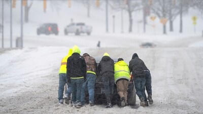 Good Samaritans help a driver out after his rear-wheel drive vehicle got stranded on Rosa L. Parks Blvd. after a winter storm in Nashville, Tenn., Monday, Jan. 15, 2024. (Denny Simmons/The Tennessean via AP) (AP)