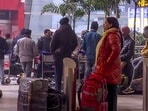 Passengers await at the Indira Gandhi International Airport on a cold winter morning, in New Delhi on Tuesday. 
