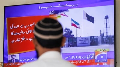 A man looks at a television screen after the Pakistani foreign ministry said the country conducted strikes inside Iran targeting separatist militants, (REUTERS)