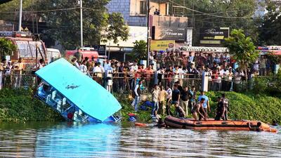 People gather during a rescue and search operation near a lake in Vadodara on Thursday. (PTI) People gather during a rescue and search operation near a lake in Vadodara on Thursday. (PTI)