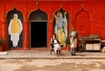 People at the premises of a temple, next to the cutouts of Prime Minister Narendra Modi and the Lord Ram in Ayodhya. (REUTERS) People at the premises of a temple, next to the cutouts of Prime Minister Narendra Modi and the Lord Ram in Ayodhya. (REUTERS)
