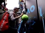 Italy's Jannik Sinner gives autographs to fans after victory against Argentina's Sebastian Baez during their men's singles match on day six of the Australian Open tennis tournament in Melbourne on January 19