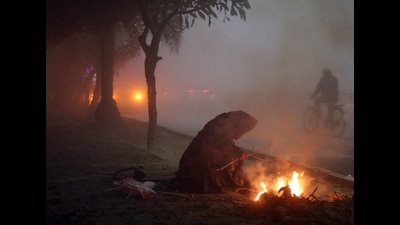 A woman warms herself near a fire amid heavy evening fog, in Amritsar on Thursday. Cold weather conditions continued to persist in Punjab and Haryana, with Bathinda and Sirsa being the coldest places in the two states on Friday. (ANI)