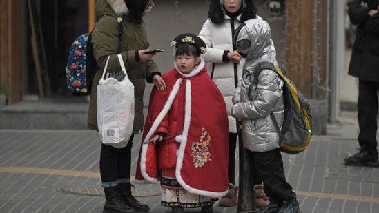 TOPSHOT - People are seen on a street in Beijing on January 17, 2024. China's population decline accelerated in 2023, official data showed on january 17, 2024, extending a downward streak after more than six decades of growth as the country battles a looming demographic crisis. (Photo by Pedro PARDO / AFP) (AFP)
