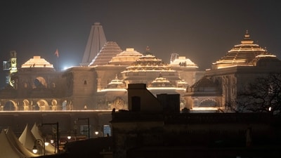 Labourers work on top of the illuminated grand temple of Lord Ram ahead of its opening in Ayodhya. (REUTERS)