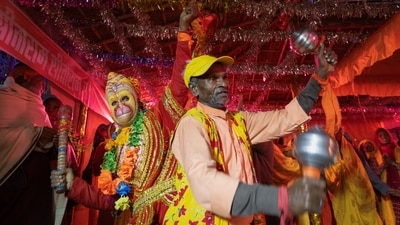 A man dressed as Lord Hanuman dances with Hindu devotees at the tent city built for the pilgrims on the banks of the Sarayu river ahead of the opening of the grand temple of Lord Ram in Ayodhya. (REUTERS)