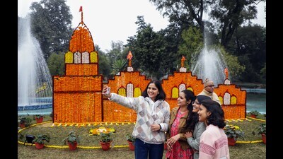 Visitors pose for a selfie in front of a Ram temple model made with flowers at a flower exhibition organised in Lucknow on Saturday. (ANI)