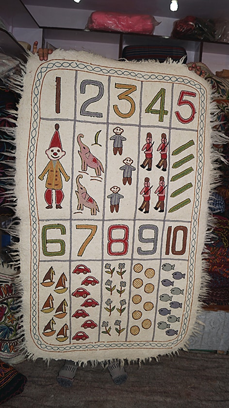 The awwal naksh, a type of namdah or felt rug designed for children, usually features toys, fruit and numerals. The awwal naksh, a type of namdah or felt rug designed for children, usually features toys, fruit and numerals.
