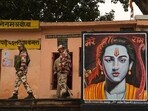 Security personnel walk past a poster of Lord Ram, ahead of the consecration ceremony of Ram Mandir, in Ayodhya, on January 20. Security personnel walk past a poster of Lord Ram, ahead of the consecration ceremony of Ram Mandir, in Ayodhya, on January 20.