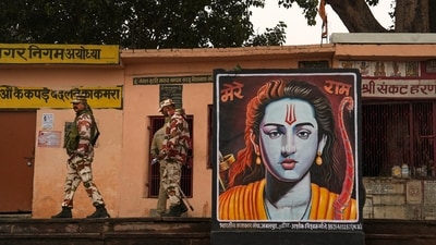 Security personnel walk past a poster of Lord Ram, ahead of the consecration ceremony of Ram Mandir, in Ayodhya, on January 20. (PTI) Security personnel walk past a poster of Lord Ram, ahead of the consecration ceremony of Ram Mandir, in Ayodhya, on January 20. (PTI)