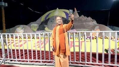 Chief minister Yogi Adityanath takes a selfie with a sand sculpture of Lord Ram in the background, in Ayodhya on Sunday. (ANI PHOTO)