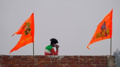Ayodhya: A man talks on his phone after hoisting of religious flags on his house ahead of the consecration ceremony of Ram Mandir, in Ayodhya, Saturday, Jan. 20, 2024. (Representational Image/PTI) Ayodhya: A man talks on his phone after hoisting of religious flags on his house ahead of the consecration ceremony of Ram Mandir, in Ayodhya, Saturday, Jan. 20, 2024. (Representational Image/PTI)