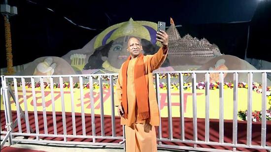 Chief minister Yogi Adityanath takes a selfie with a sand sculpture of Lord Ram in the background, in Ayodhya on Sunday. (ANI PHOTO)