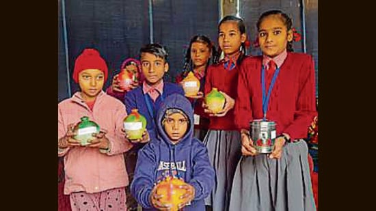 Children with their piggy banks at a makeshift school in Ludhiana. (HT)