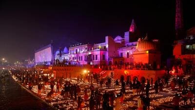 Devotees light diyas on the bank of the Sarayu river. (REUTERS) Devotees light diyas on the bank of the Sarayu river. (REUTERS)