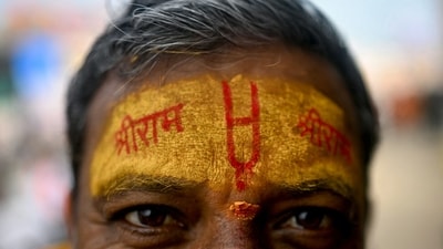 A devotee with his forehead marked with the name of Lord Ram looks on in Ayodhya on January 21, on the eve of the consecration ceremony of Ram temple. (AFP) A devotee with his forehead marked with the name of Lord Ram looks on in Ayodhya on January 21, on the eve of the consecration ceremony of Ram temple. (AFP)